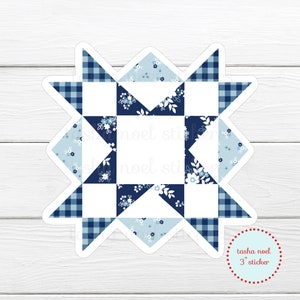 May include: A die-cut sticker in the shape of a star, featuring a quilt block design. The design incorporates white, light blue, and navy blue floral and gingham patterns. The sticker is 3 inches in diameter, with the text "tasha noel 3" sticker" in a red circle.