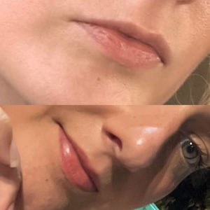 May include: Close-up of a person's face, focusing on the lips. The upper lip is a light pink, and the lower lip is a glossy, darker pink. The skin around the lips is fair.