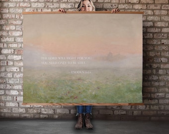 May include: A large wall art print with a landscape scene in muted colors of green, peach, and beige. The print has a wooden frame and features the text "THE LORD WILL FIGHT FOR YOU, YOU NEED ONLY TO BE STILL - EXODUS 14:14."