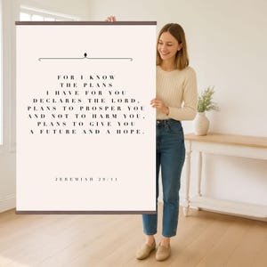 Könnte beinhalten: Ein gerahmter Wandkunstdruck mit dem Text "FOR I KNOW THE PLANS I HAVE FOR YOU DECLARES THE LORD, PLANS TO PROSPER YOU AND NOT TO HARM YOU, PLANS TO GIVE YOU A FUTURE AND A HOPE." Der Text ist schwarz auf cremefarbenem Hintergrund.