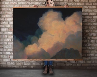 May include: A large rectangular canvas art piece featuring a dramatic cloudscape. The artwork showcases a dark blue sky contrasting with fluffy, peach-colored clouds. The canvas is framed with a light-colored wooden border.