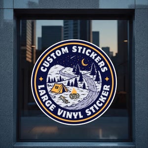 Puede incluir: Una pegatina circular con una escena de acampada. El diseño presenta una carretera que serpentea por un bosque bajo un cielo estrellado con una luna creciente. El texto alrededor del borde dice "CUSTOM STICKERS LARGE VINYL STICKER". La pegatina tiene un esquema de color amarillo, azul y blanco.