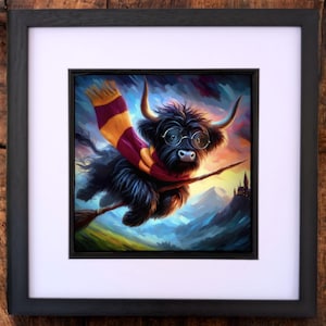 May include: A framed art print featuring a whimsical illustration of a black Highland cow wearing round glasses and a striped scarf, riding a broomstick. The background shows a castle and a colorful sky.
