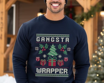 Pode incluir: Uma camisa de frio azul marinho com um design temático de Natal. O design apresenta uma árvore de Natal verde com presentes vermelhos e o texto "Gangsta Wrapper".