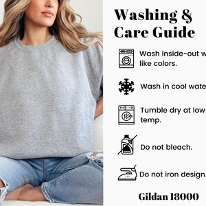 K&ouml;nnte beinhalten: Wasch- und Pflegehinweise f&uuml;r ein graues Sweatshirt. Von links waschen mit &auml;hnlichen Farben, in kaltem Wasser waschen, im Trockner bei niedriger Temperatur trocknen, nicht bleichen und das Design nicht b&uuml;geln. Gildan 18000.