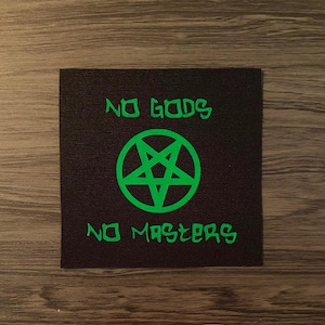 May include: Square black patch with the words "NO GODS" above a green pentagram and the words "NO MASTERS" below. The text and pentagram are in a bright green color.