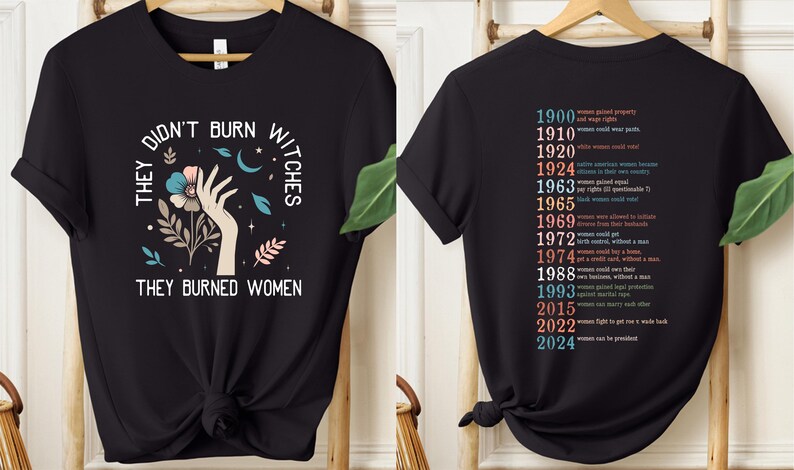 May include: Black t-shirt featuring the text "THEY DIDN'T BURN WITCHES THEY BURNED WOMEN" and a graphic of a hand, flowers, and celestial elements. The back lists women's rights milestones from 1900 to 2024.