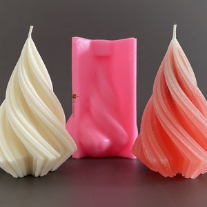Könnte beinhalten: Zwei Spiralkerzen, eine weiße und eine rosa, sowie eine rosa Silikonform zum Herstellen von Spiralkerzen.