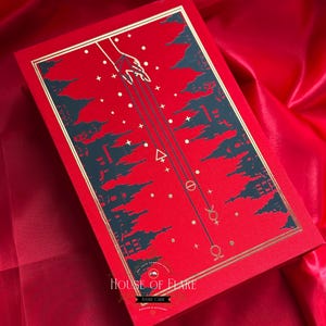 K&ouml;nnte beinhalten: Rote rechteckige Box mit goldenem Rand und Himmelsdesign. Der Deckel zeigt eine Hand, die sich mit Linien, Sternen und Symbolen nach unten erstreckt. Der Text "HOUSE OF FLARE" ist sichtbar.