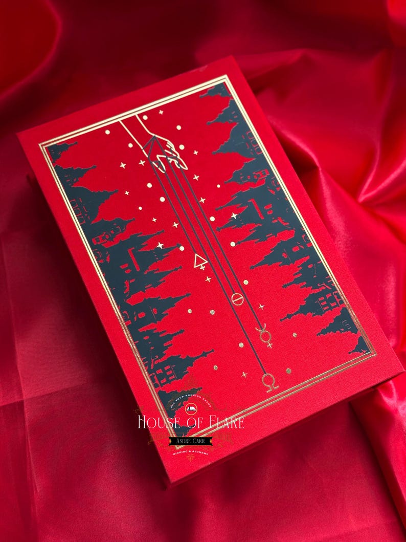 K&ouml;nnte beinhalten: Rote rechteckige Box mit goldenem Rand und Himmelsdesign. Der Deckel zeigt eine Hand, die sich mit Linien, Sternen und Symbolen nach unten erstreckt. Der Text "HOUSE OF FLARE" ist sichtbar.