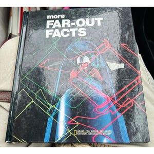 May include: A vintage hardcover book titled "more FAR-OUT FACTS" with a black cover. The cover features a colorful illustration of a person in a helmet and a futuristic vehicle, with neon lines overlaying the image. The book is from the National Geographic Society.