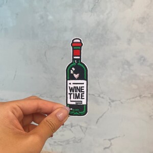 Può includere: Toppa ricamata verde e rossa da stirare a forma di bottiglia di vino con la scritta "Wine Time" sull'etichetta.