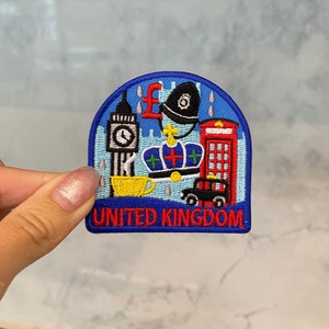 May include: An embroidered patch featuring iconic London landmarks, including Big Ben, a red telephone box, a crown, a policeman's hat, a cup of tea, and a taxi. The text "UNITED KINGDOM" is embroidered in red at the bottom of the patch.