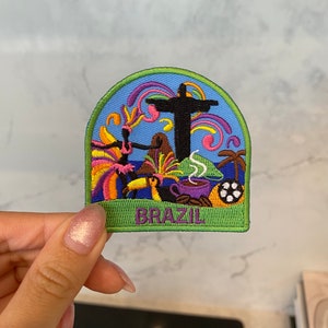 Puede incluir: Un parche bordado colorido que representa a Cristo Redentor, un tucán, una taza de café y la palabra "BRASIL".