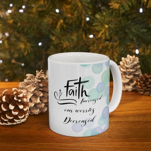 May include: White ceramic mug with a teal and purple watercolor design. The mug features the text "Faith increased our worries decreased".