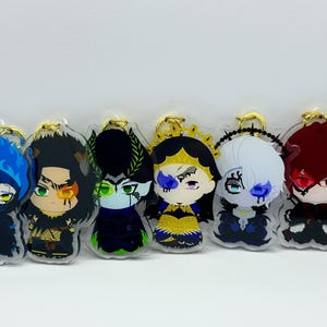 May include: Set of seven colourful character keychains. Each keychain features a different character with unique facial features and clothing. The characters are depicted in a cartoon style and are made of clear acrylic.