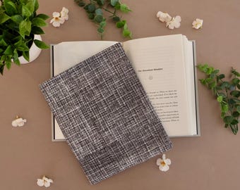 May include: A black and white patterned book cover with the text "The Abundant Mindset" on the open book page.