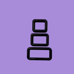May include: Three black rectangular metal rings stacked vertically against a purple background. The rings are of varying sizes, with the largest at the bottom and the smallest at the top. The rings have rounded corners.