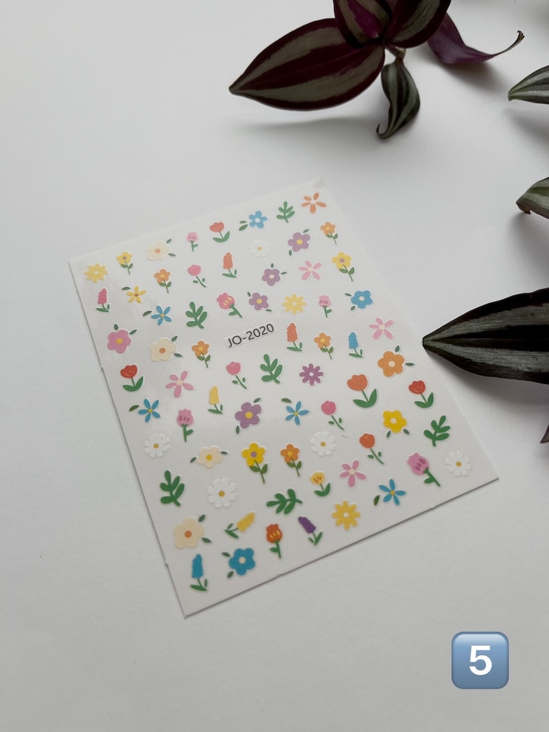 May include: A sheet of colorful flower stickers with a white background. The stickers feature various flowers in shades of pink, yellow, blue, and green. The sheet is labeled "JO-2020" in the center.