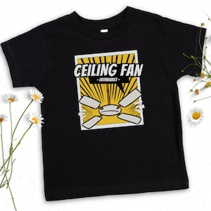May include: Black t-shirt with a yellow and black graphic of a ceiling fan. The graphic says "Ceiling Fan - Enthusiast - "