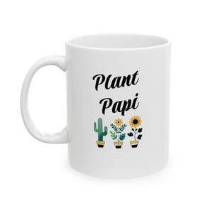 May include: White ceramic mug with a black graphic that says "Plant Papi" and features a cactus and sunflowers in pots.