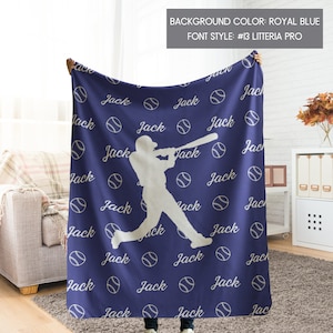 May include: A blue fleece blanket featuring a white silhouette of a baseball player and the name "Jack" repeated throughout the design. The background colour is royal blue and the font style is #13 Litteria Pro.