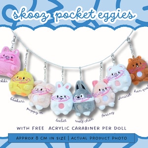 Könnte beinhalten: Eine Auswahl an farbenfrohen Pocket Eggies aus Plüsch, jeweils etwa 8 cm groß, mit Tiermotiven. Enthält ein rosa Schwein, ein gelbes Küken und einen weißen Hasen. Inklusive Karabinerhaken aus Acryl.