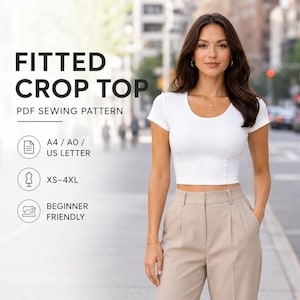 Puede incluir: Una mujer con un top corto blanco ajustado y pantalones color beige. La imagen incluye el texto "FITTED CROP TOP PDF SEWING PATTERN", detalles de tallas y "BEGINNER FRIENDLY".