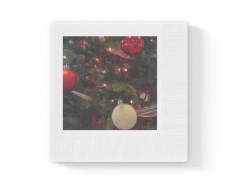 White coined napkins with evergreen branches, lights and Christmas bulbs