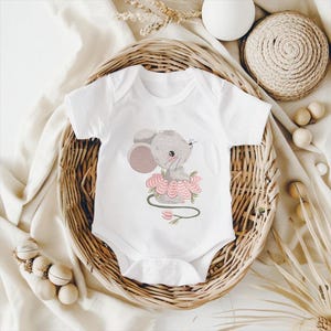 May include: White baby bodysuit with an embroidered design of a grey mouse in a pink flower. The bodysuit has short sleeves and a snap closure. The design includes a green stem and pink flower details.