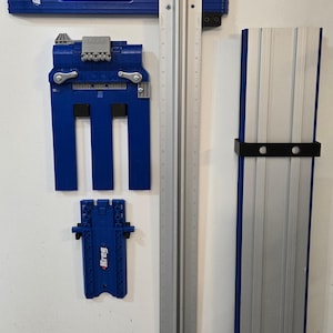 May include: A set of blue and silver Kreg jig tools for woodworking. The set includes a track, a jig, and a guide. The tools are used to create pocket holes for joining wood.