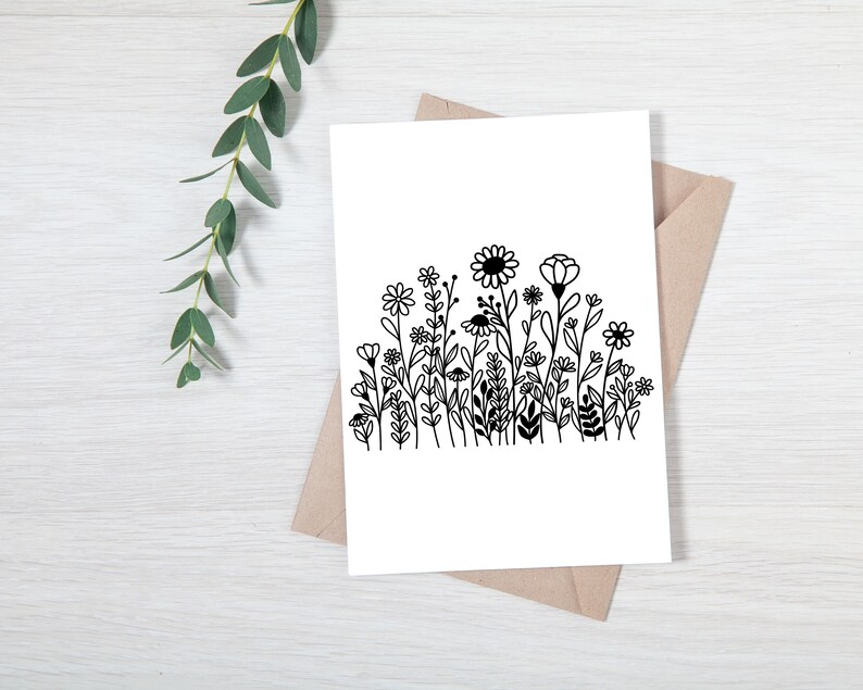 May include: A black and white illustration of a field of wildflowers. The flowers are drawn in a simple, stylized way, with rounded petals and stems.