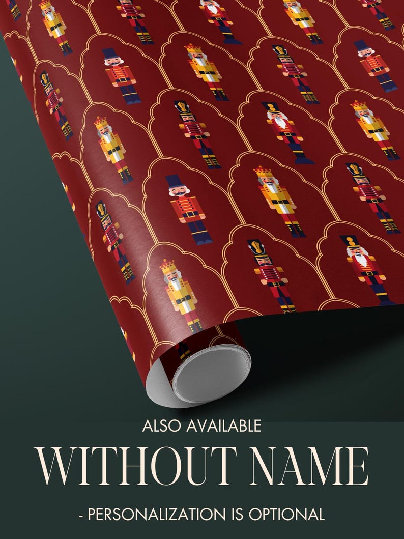 May include: Rolled wrapping paper with a repeating pattern of nutcracker soldiers in red, gold, and blue. The paper has a dark red background with a gold decorative border. Text at the bottom reads "ALSO AVAILABLE WITHOUT NAME - PERSONALIZATION IS OPTIONAL."