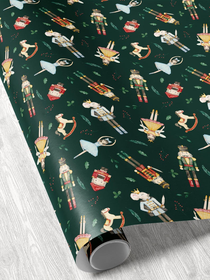 May include: Dark green wrapping paper with a repeating pattern of watercolor illustrations. The design includes nutcrackers, ballerinas, toy soldiers, toy mice, rocking horses, and small red gift boxes. The paper is rolled up, showing the pattern.
