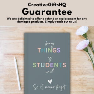 Pode incluir: Um di&aacute;rio cinza com o texto "funny THINGS my STUDENTS said So i'll never forget" em letras coloridas. O di&aacute;rio est&aacute; sobre uma superf&iacute;cie de madeira com flores cor-de-rosa.