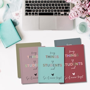 Pode incluir: Quatro cadernos de cores diferentes com o texto "funny things my students said" e um cora&ccedil;&atilde;o com o texto "so i'll never forget" na frente.
