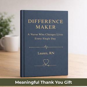 Pode incluir: Um livro azul marinho com letras douradas que diz "DIFFERENCE MAKER" e "A Nurse Who Changes Lives Every Single Day". O livro também inclui o nome "Lauren, RN" e um gráfico de estetoscópio. O texto "Meaningful Thank You Gift" está na parte inferior.