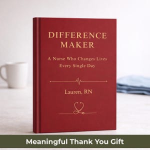 Pode incluir: Um livro vermelho com letras douradas que diz "DIFFERENCE MAKER" e "A Nurse Who Changes Lives Every Single Day." Abaixo do texto está "Lauren, RN" e um gráfico de estetoscópio. Uma caneca branca está no fundo.