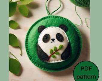 May include: A green felt ornament with a white panda bear holding a green leaf. The ornament has a loop for hanging and says "PDF pattern" in white text on a green circle.