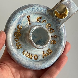 Blå och guldfärgad ljusstake i keramik med affirmationen ”Jag skapar min egen magi”