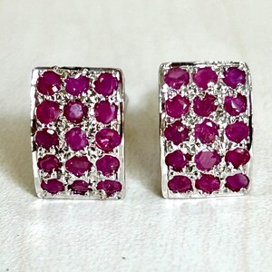 May include: A pair of silver earrings with a rectangular shape. Each earring is set with a cluster of small, round, ruby red gemstones.