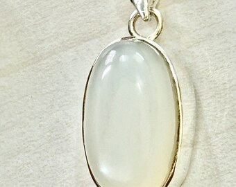 May include: A silver pendant necklace with a white oval moonstone.