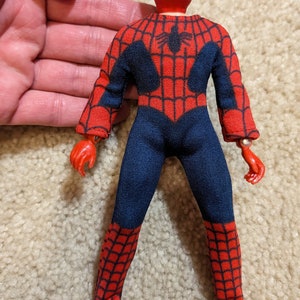 Peut inclure: Une figurine d'action Spider-Man rouge et bleue avec un masque rouge et un motif de toile d'araign&eacute;e. La figurine a des bras et des jambes articul&eacute;s.