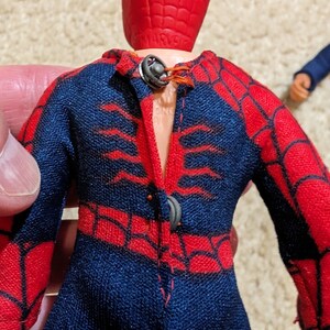 Peut inclure: Une figurine vintage de Spider-Man avec un costume rouge et bleu et un masque rouge. La figurine a un motif de toile d'araign&eacute;e sur le costume et manque de bras.