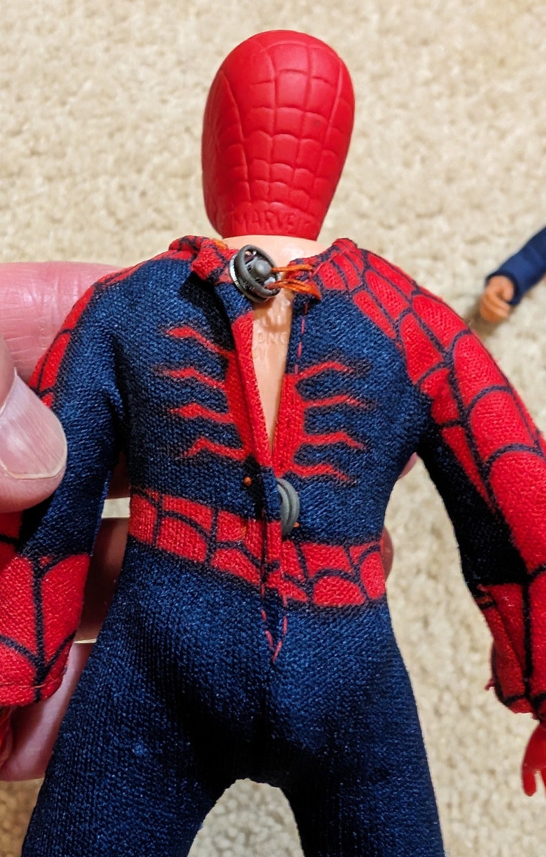 Peut inclure: Une figurine vintage de Spider-Man avec un costume rouge et bleu et un masque rouge. La figurine a un motif de toile d'araign&eacute;e sur le costume et manque de bras.