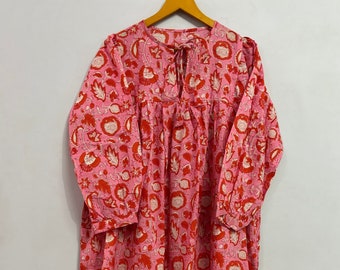 May include: A pink and red long-sleeved dress with a floral print. The dress has a gathered waist and a tie at the neckline.