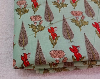 May include: A light green fabric with a repeating pattern of brown leaves, red and pink flowers, and green stems.