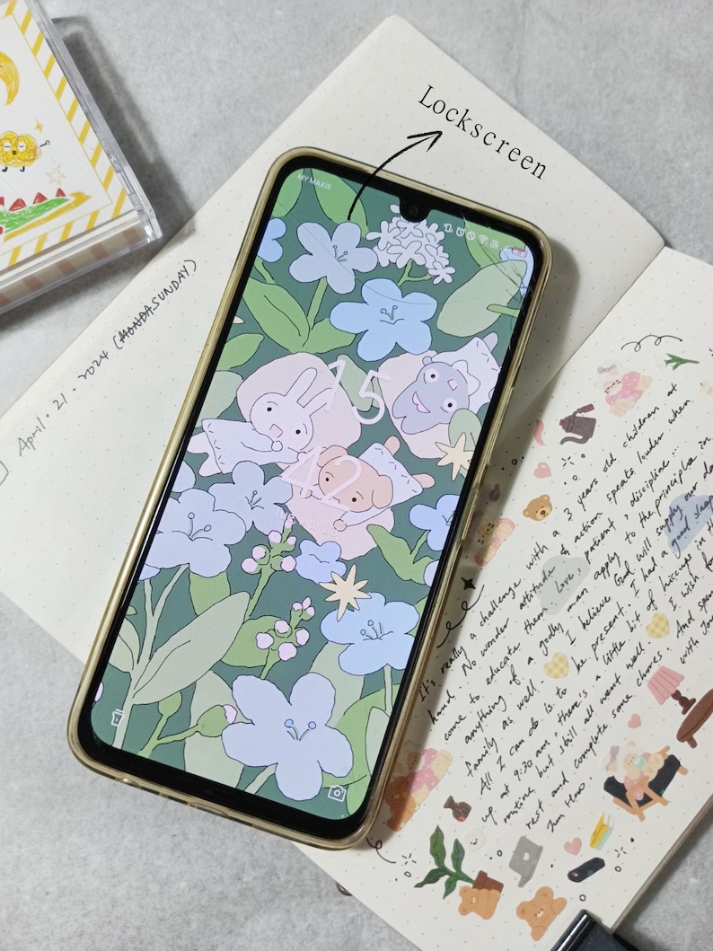 May include: A gold smartphone with a floral and cartoon character wallpaper. The screen displays the time and a star icon. The text "Lockscreen" is written above the phone.