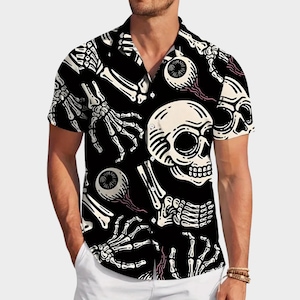 Könnte beinhalten: Schwarzes kurzärmeliges Hemd mit einem sich wiederholenden Muster aus weißen Totenköpfen, Augäpfeln und Skeletthänden. Das Hemd hat einen klassischen Kragen und ist aus leichtem Stoff gefertigt. Ein Halloween-Themen-Kleidungsstück.