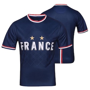 K&ouml;nnte beinhalten: Ein marineblaues Kurzarmtrikot mit dem Wort "FRANCE" in wei&szlig;en Blockbuchstaben. Zwei goldene Sterne befinden sich &uuml;ber dem Wort. Das Trikot hat rot-wei&szlig;e Verzierungen am Kragen und an den &Auml;rmeln. Die R&uuml;ckseite des Trikots ist ebenfalls sichtbar.
